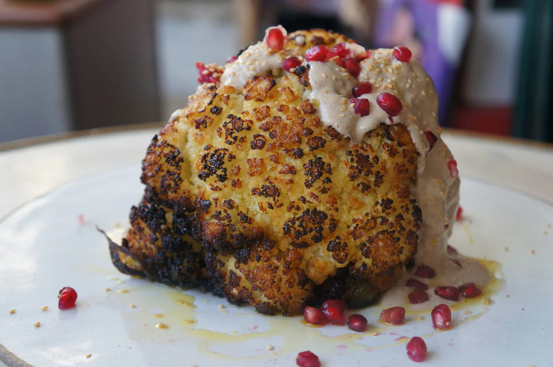 Whole Head Of Roasted Cauliflower with tahini, toasted sesame seeds, pomegranate and fresh parsley